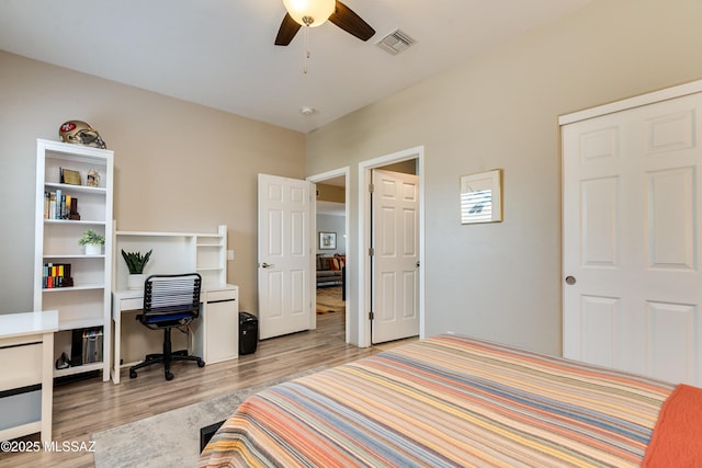 bedroom with visible vents, light wood-style flooring, and a ceiling fan