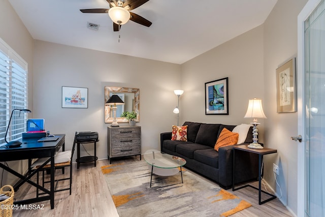 living area with visible vents, wood finished floors, and a ceiling fan