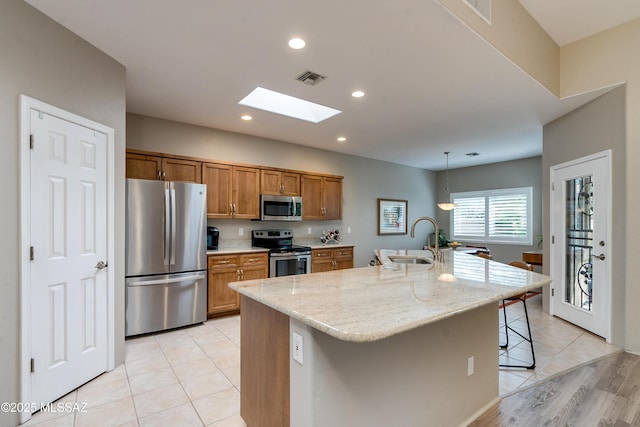 kitchen with visible vents, a skylight, a sink, appliances with stainless steel finishes, and brown cabinets