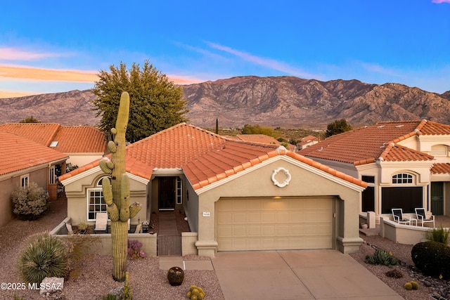 mediterranean / spanish-style home with a tile roof, a mountain view, and stucco siding