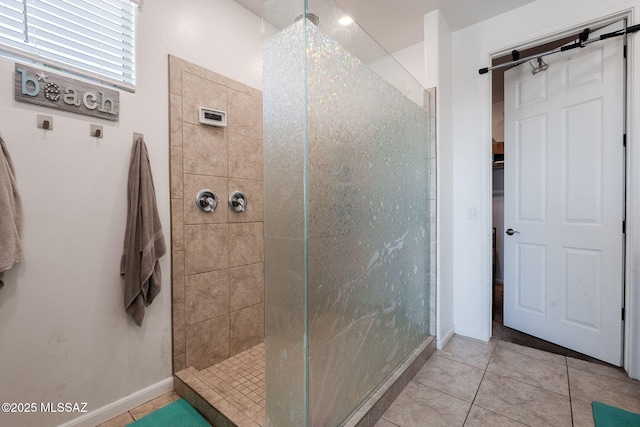 bathroom featuring a tile shower and tile patterned flooring