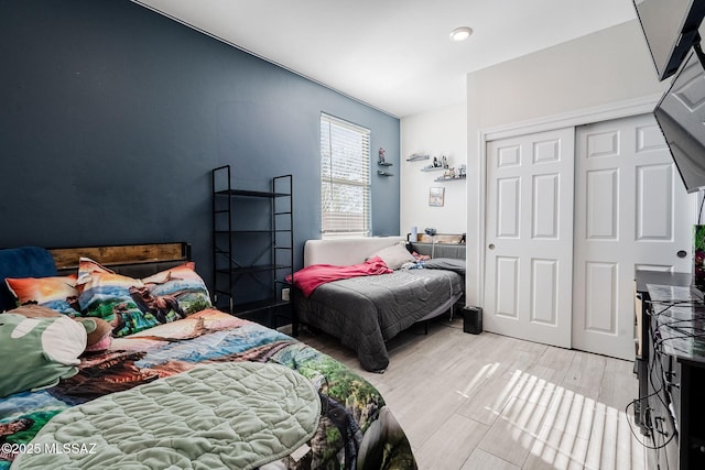 bedroom with light hardwood / wood-style floors and a closet