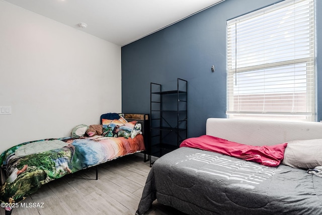 bedroom featuring hardwood / wood-style floors and vaulted ceiling