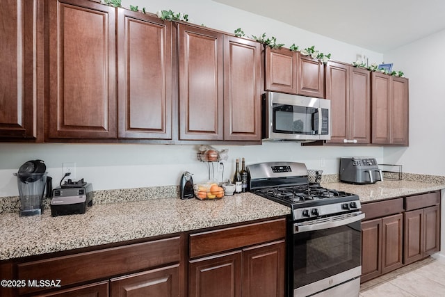 kitchen with light tile patterned floors and appliances with stainless steel finishes