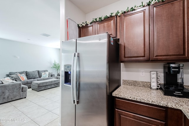 kitchen featuring light tile patterned floors and stainless steel refrigerator with ice dispenser