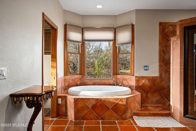 bathroom featuring tile patterned flooring and tiled bath