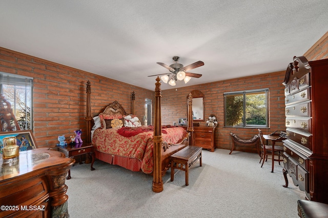 carpeted bedroom with ceiling fan, brick wall, and a textured ceiling