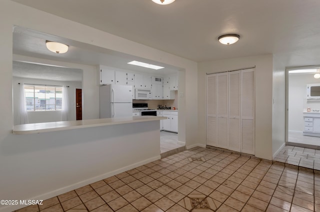 kitchen with light countertops, white appliances, a peninsula, and white cabinetry