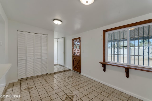 entrance foyer featuring baseboards and light tile patterned floors