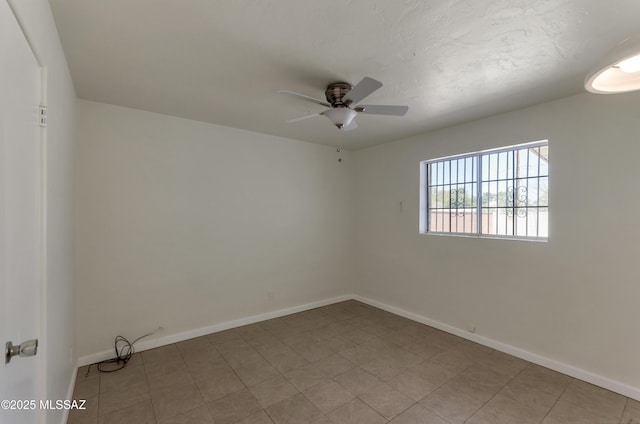 empty room featuring ceiling fan and baseboards