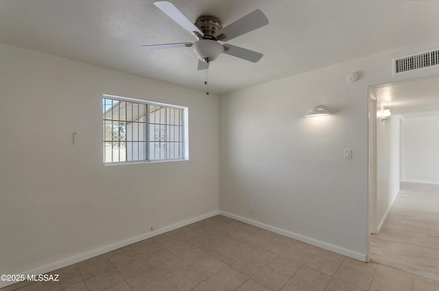 spare room featuring ceiling fan, light tile patterned flooring, visible vents, and baseboards