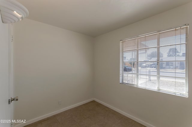 empty room featuring light tile patterned flooring and baseboards