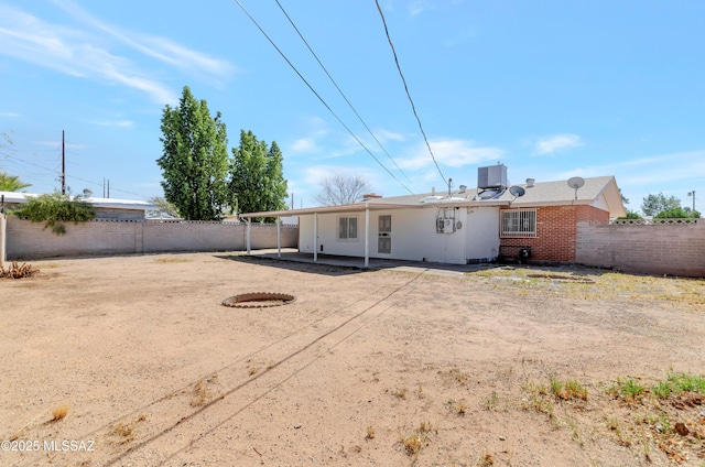 rear view of property featuring brick siding, a patio area, and a fenced backyard