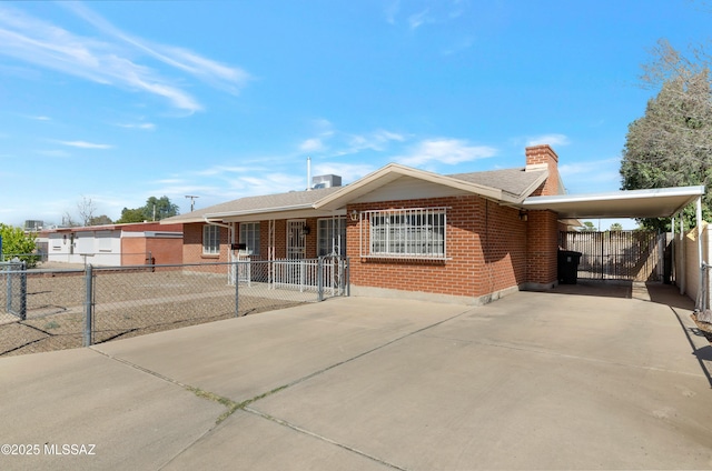 ranch-style home featuring driveway, fence, an attached carport, and brick siding