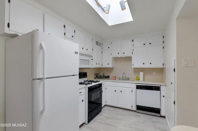 kitchen featuring white appliances, tasteful backsplash, white cabinets, light countertops, and a sink