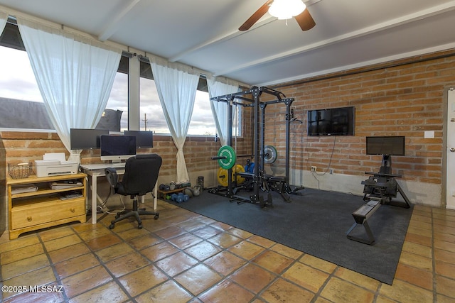 interior space with brick wall and a ceiling fan