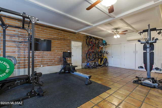 workout area with coffered ceiling, brick wall, and ceiling fan