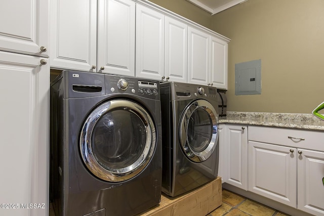 washroom featuring electric panel, cabinet space, and washer and clothes dryer