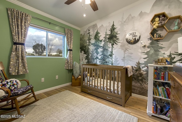 bedroom with baseboards, a ceiling fan, wood finished floors, and crown molding