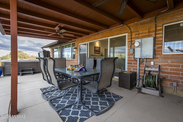 view of patio featuring ceiling fan, outdoor dining area, and a hot tub