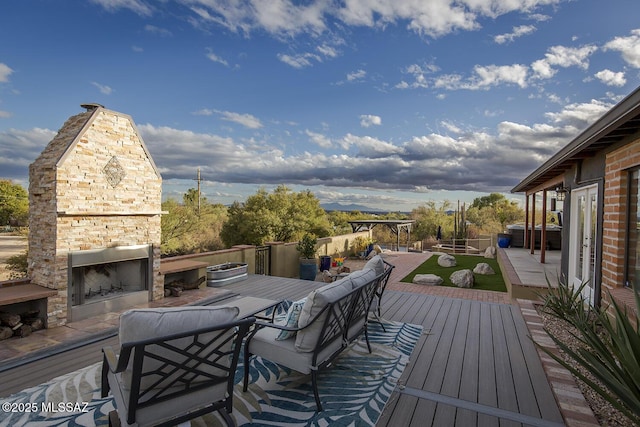 wooden deck with a patio, outdoor dining area, and an outdoor stone fireplace