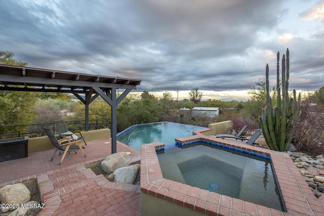 view of swimming pool featuring a patio area and a pool with connected hot tub