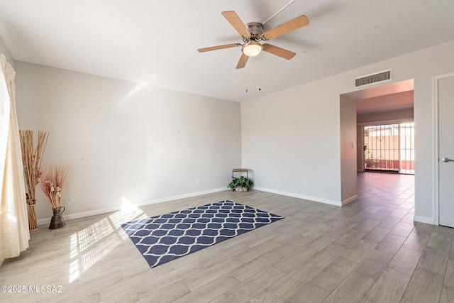 unfurnished room featuring ceiling fan, light wood-type flooring, visible vents, and baseboards