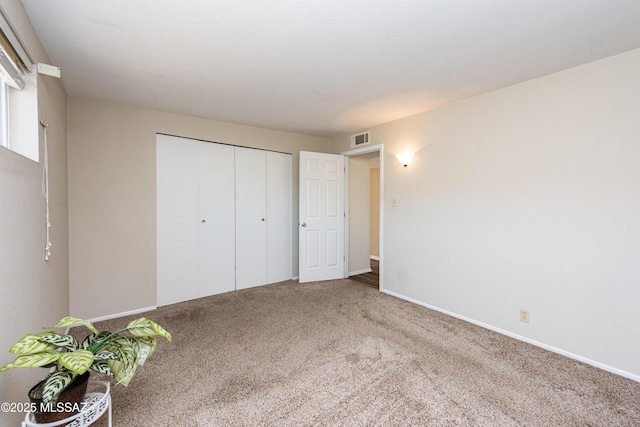 unfurnished bedroom with carpet flooring and a closet