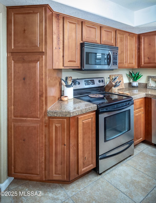 kitchen featuring light tile patterned flooring and appliances with stainless steel finishes