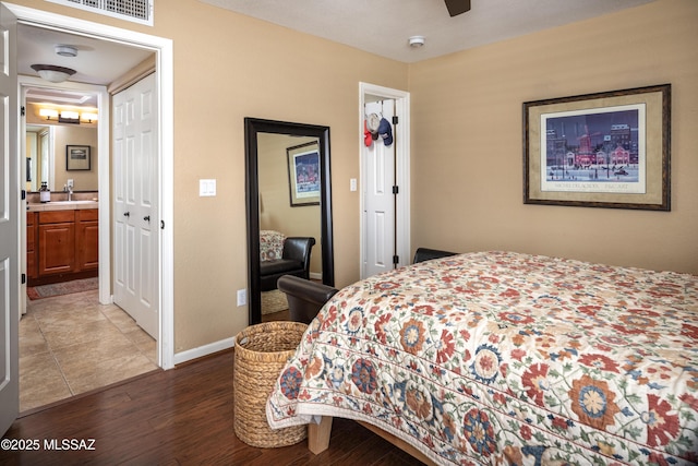 bedroom featuring dark hardwood / wood-style floors, connected bathroom, and ceiling fan