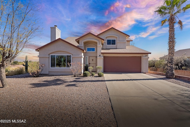 view of front of house featuring a garage, concrete driveway, a chimney, and stucco siding