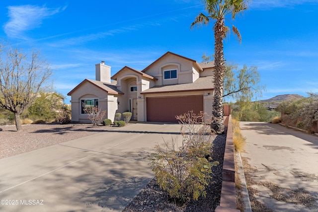 view of front of home featuring a garage, driveway, a chimney, and stucco siding