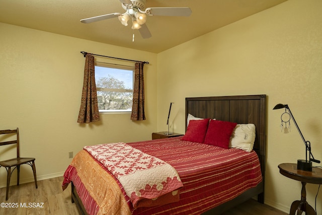 bedroom with baseboards, ceiling fan, and light wood-style floors