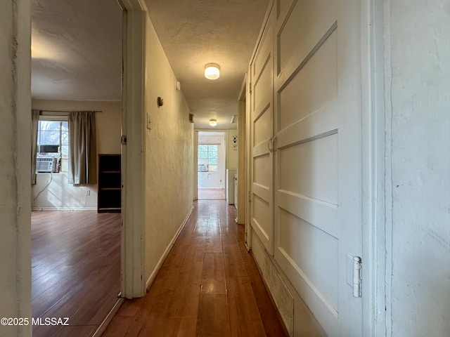 corridor featuring a wealth of natural light, baseboards, and hardwood / wood-style flooring