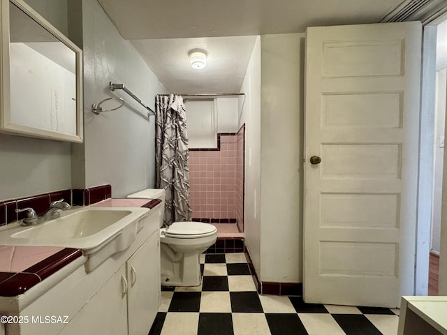 bathroom with toilet, a stall shower, vanity, and tile patterned floors