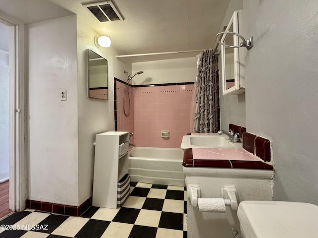 full bath featuring visible vents, toilet, washtub / shower combination, a sink, and tile patterned floors