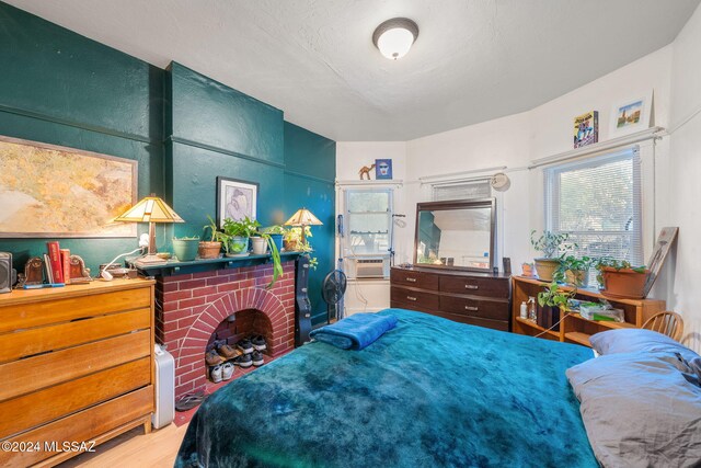 bedroom with cooling unit and a fireplace