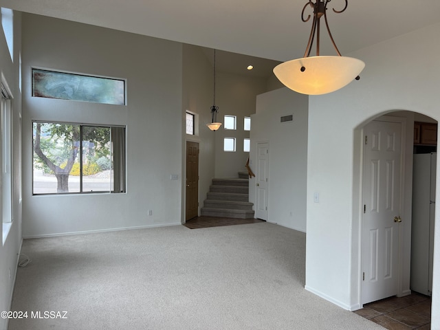 carpeted empty room with a high ceiling