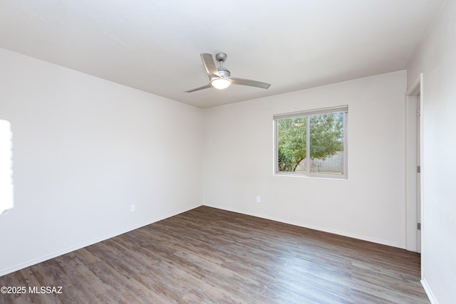spare room featuring ceiling fan, baseboards, and wood finished floors