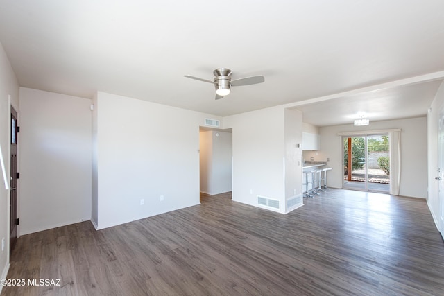 unfurnished living room with ceiling fan, visible vents, and wood finished floors