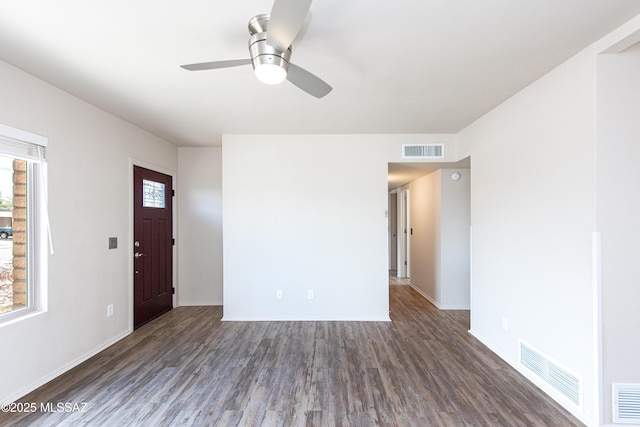 unfurnished living room with visible vents, a healthy amount of sunlight, and wood finished floors