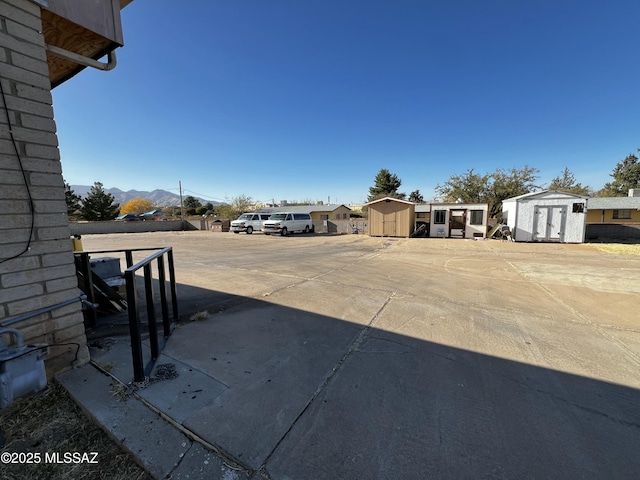 view of yard featuring a shed, a mountain view, and an outbuilding