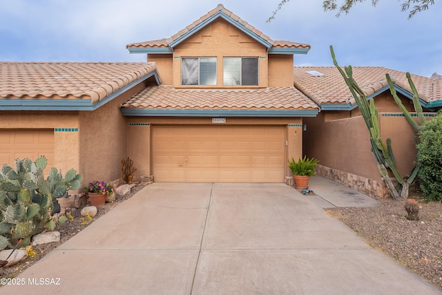 view of front of home featuring an attached garage, a tiled roof, concrete driveway, and stucco siding