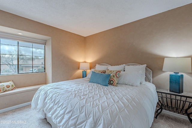 bedroom with a textured ceiling and baseboards