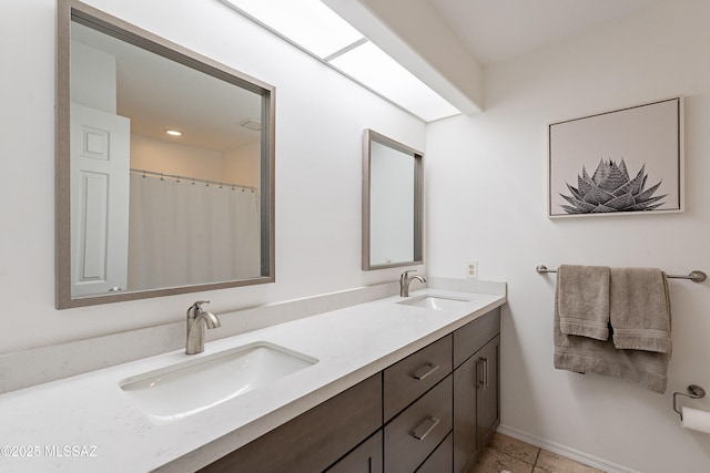 full bathroom featuring double vanity and a sink