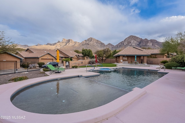 view of swimming pool with a patio area, a mountain view, fence, and a fenced in pool