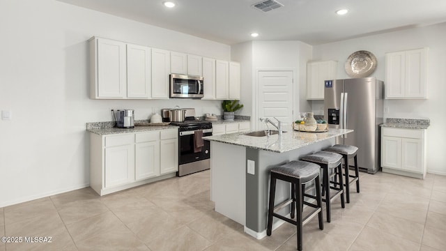 kitchen featuring white cabinetry, an island with sink, stainless steel appliances, and sink