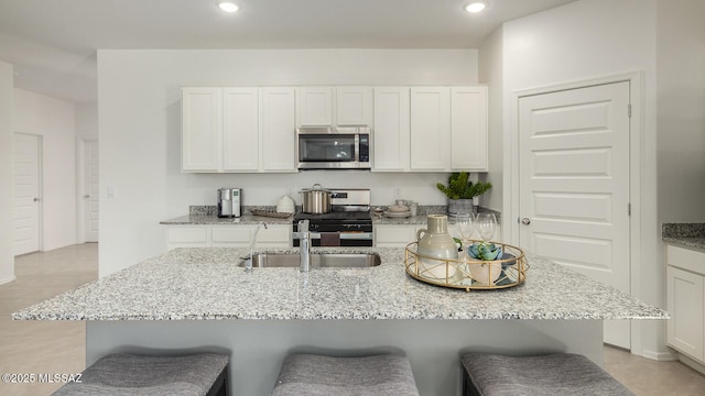 kitchen with white cabinetry, stainless steel appliances, and a breakfast bar area