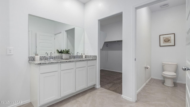 bathroom featuring tile patterned floors, vanity, and toilet