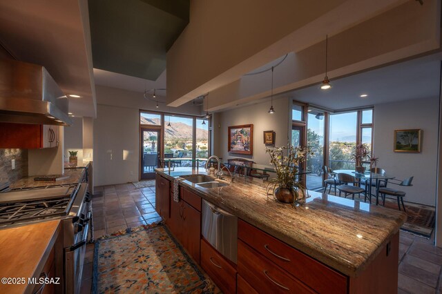 kitchen featuring a breakfast bar, backsplash, built in appliances, kitchen peninsula, and wall chimney range hood